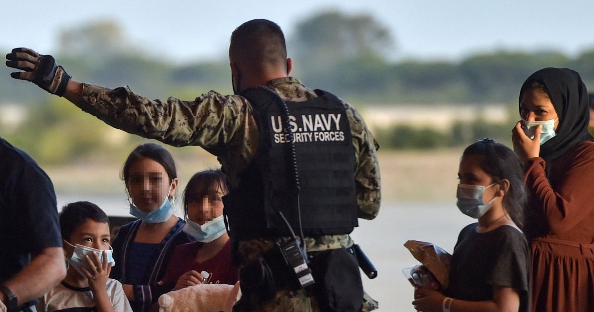 Refugees receive instructions from a U.S. navy soldier as they disembark from a US air force aircraft after an evacuation flight from Kabul at the Rota naval base in Rota, southern Spain, on Aug. 31.