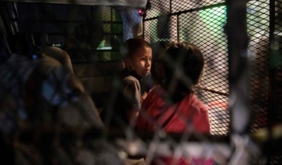 Two unaccompanied children who illegally crossed the Rio Grande from Mexico stand at a makeshift processing checkpoint before being detained by Border Patrol agents in Roma, Texas, on March 27.