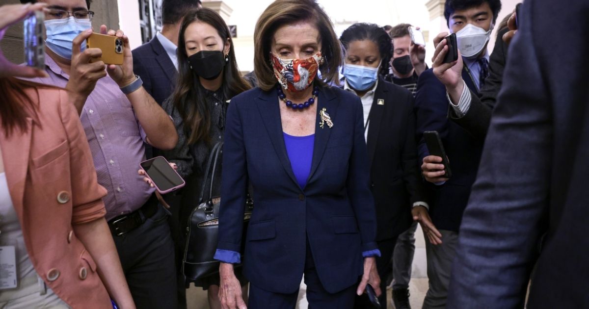 House Speaker Nancy Pelosi is surrounded by members of the media as she arrives at the U.S. Capitol on Oct. 1, 2021. House Democrats are struggling to reach a deal on an infrastructure bill after the vote was called off the previous day.