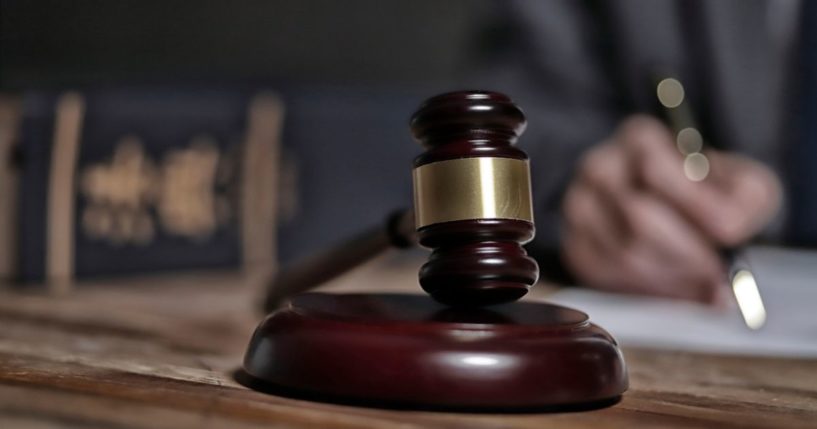 A stock photo shows a judge’s gavel lying on a wooden surface.
