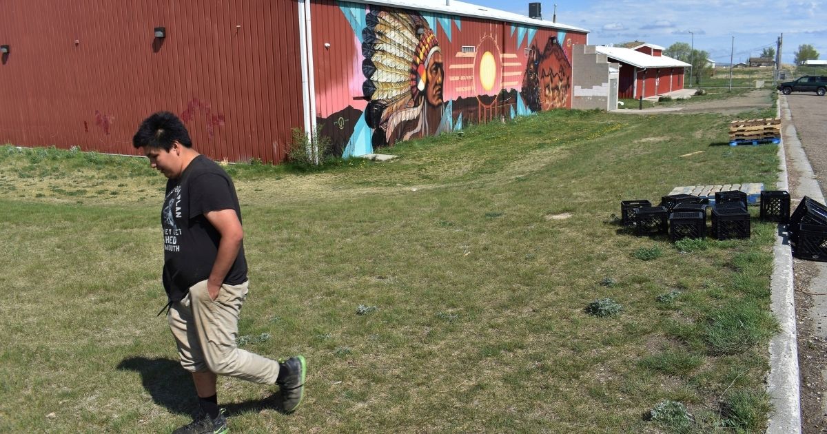A young man walks past the U.S. Post Office on the Standing Rock Sioux Reservation in Cannon Ball, N.D., on May 20, 2021.