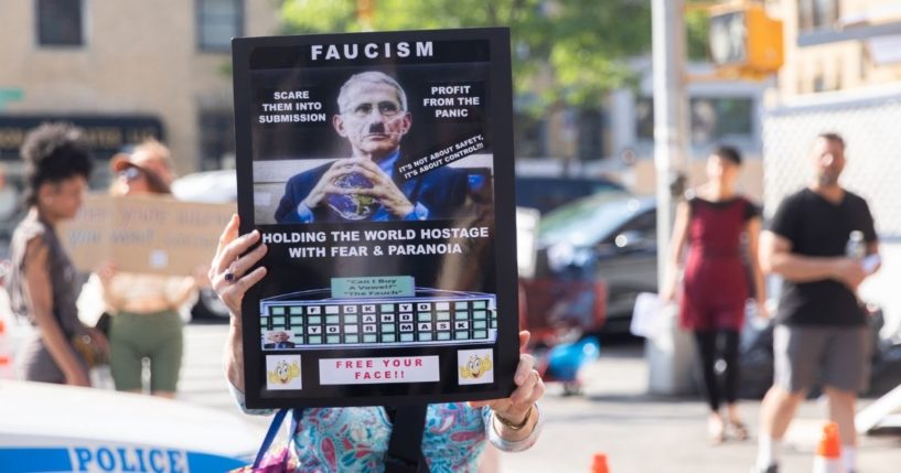 A sign likens Dr. Anthony Fauci's influence over the government to fascism during a June protest in New York City.