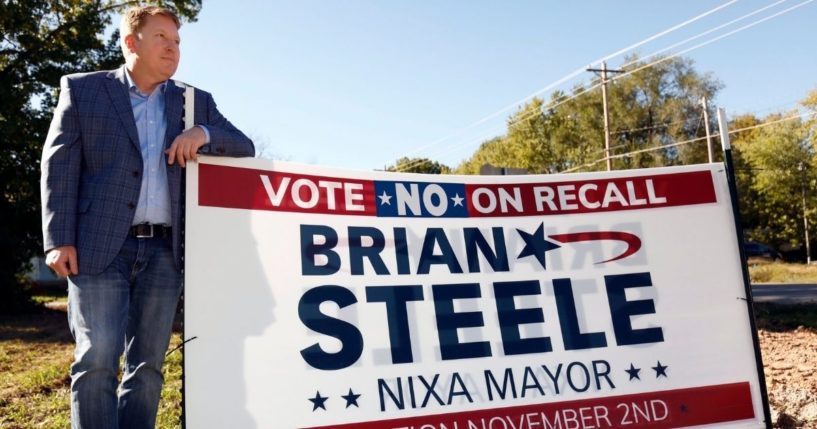 Mayor Brian Steele poses next to one of his campaign signs in Nixa, Missouri, on Oct. 21.
