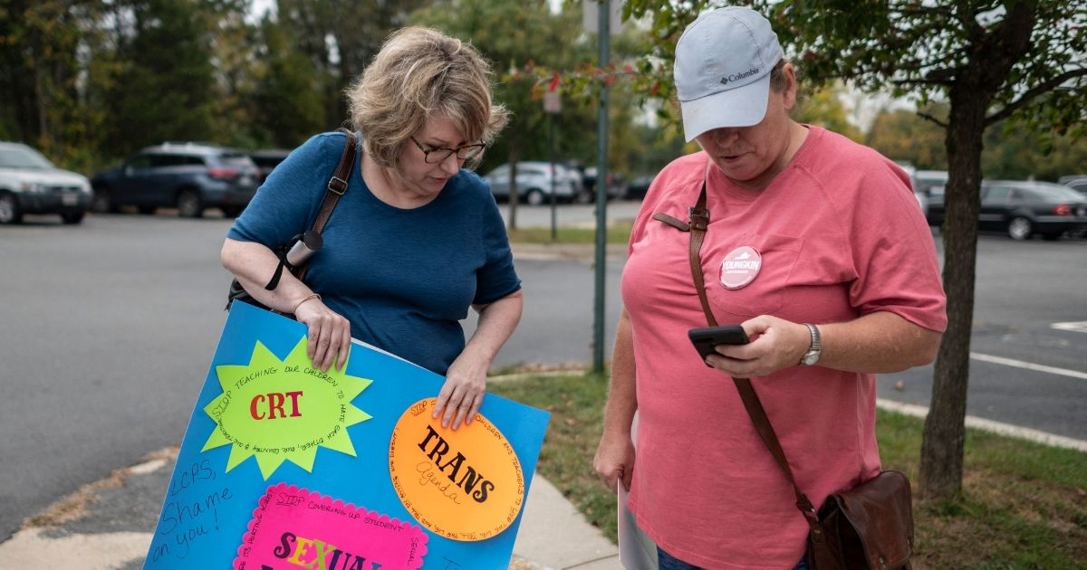 Protesters stand outside a Loudoun County Public Schools board meeting in Ashburn, Virginia, on Oct. 12.