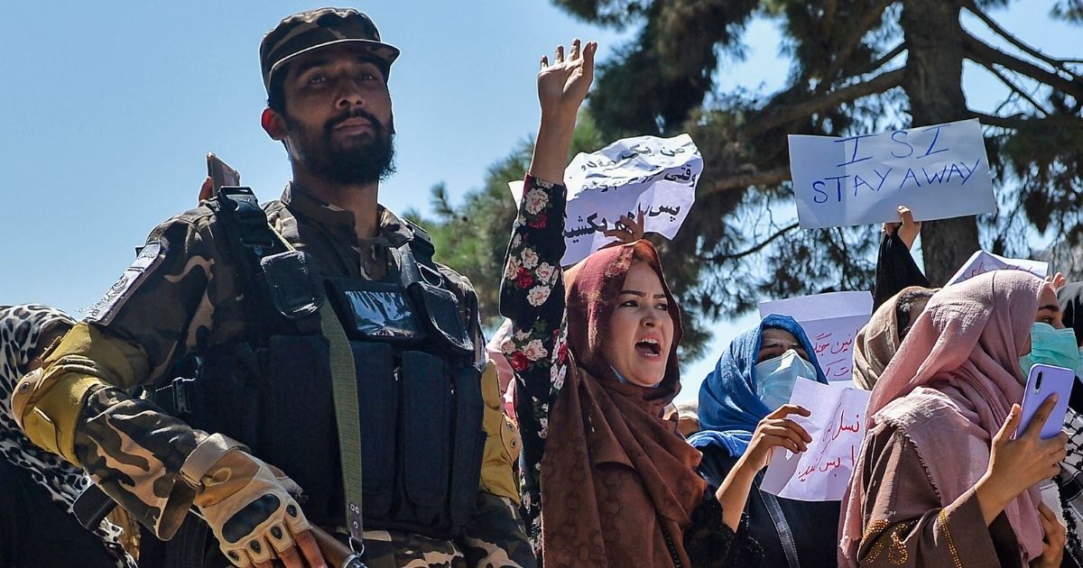 Afghan women march next to a Taliban fighter during an anti-Pakistan demonstration near the Pakistan embassy in Kabul on Sept. 7.