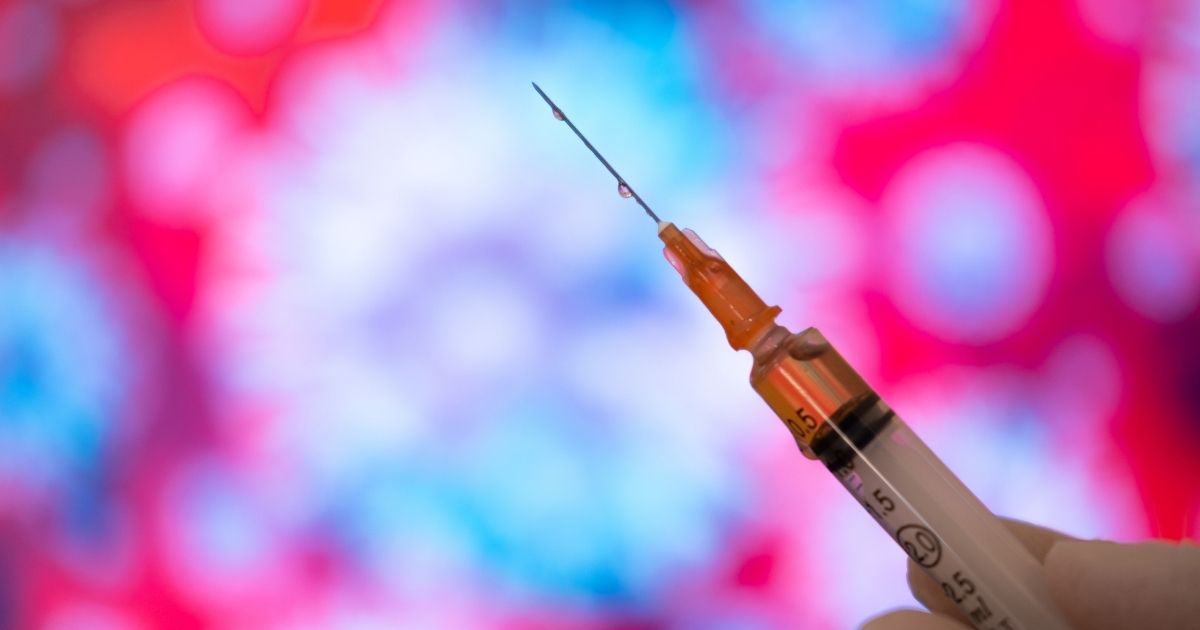 A stock photo shows a COVID-19 needle and drop.