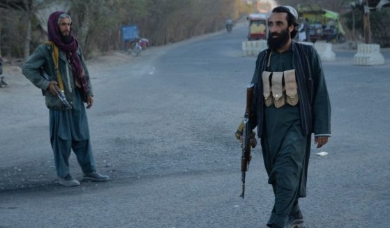 Taliban fighters stand on a road in the Injil district of the Herat Province in Afghanistan on Monday.