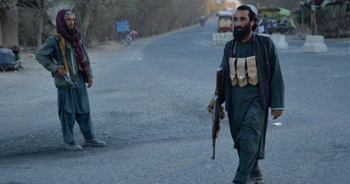Taliban fighters stand on a road in the Injil district of the Herat Province in Afghanistan on Monday.