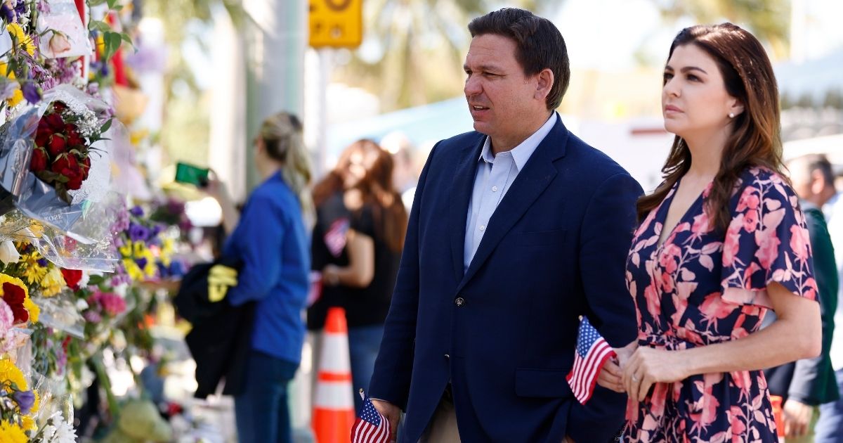 Florida Gov. Ron DeSantis and his wife, Casey, visit a memorial to those missing outside the 12-story Champlain Towers South condo building that partially collapsed in Surfside, Florida, on July 3.