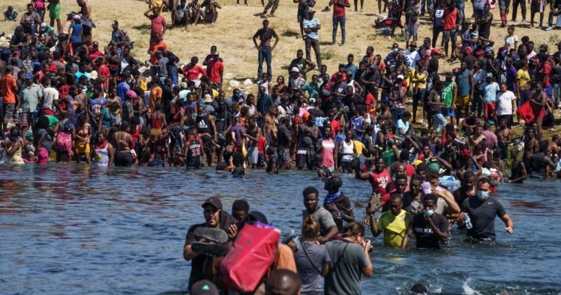Haitian migrants, part of a group of over 10,000 people staying in an encampment on the US side of the border, cross the Rio Grande river to get food and water in Mexico, after another crossing point was closed near the Acuna Del Rio International Bridge in Del Rio, Texas, on Sept. 19.