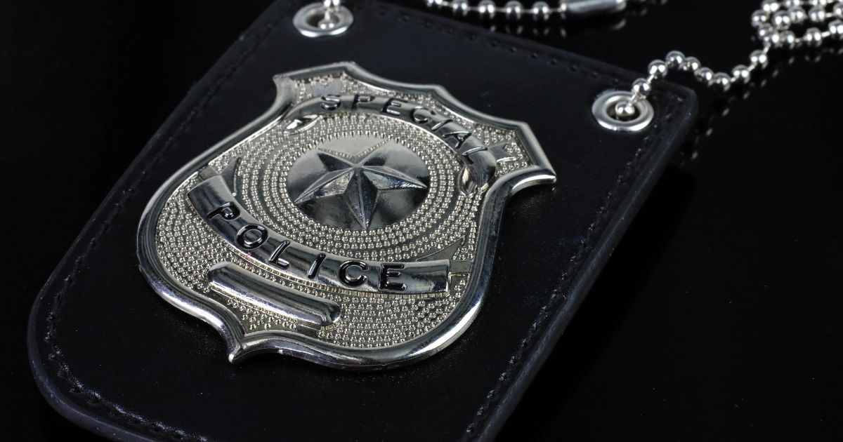 A stock photo shows a law enforcement badge.