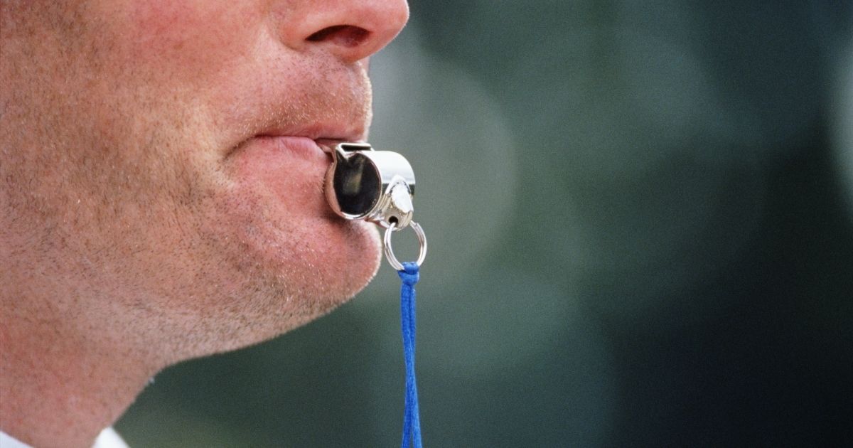 This stock photo shows a referee blowing a whistle.