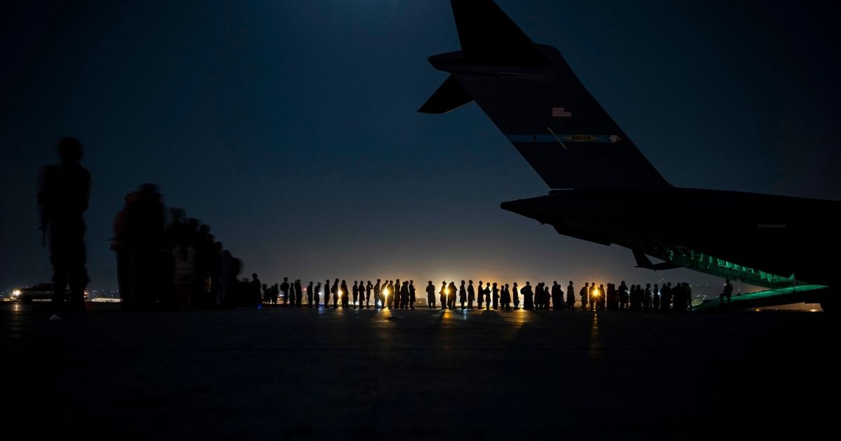 U.S. Air Force crew members prepare to load evacuees aboard an Air Force C-17 Globemaster III aircraft in Kabul, Afghanistan, on Aug. 21.
