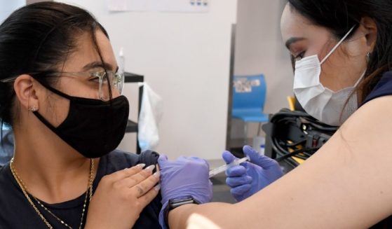 Nurse Sofia Mercado, right, administers a Moderna COVID-19 vaccination shot to Amazon employee Samantha Sanchez at the Amazon fulfillment center in North Las Vegas, Nevada, on March 31.