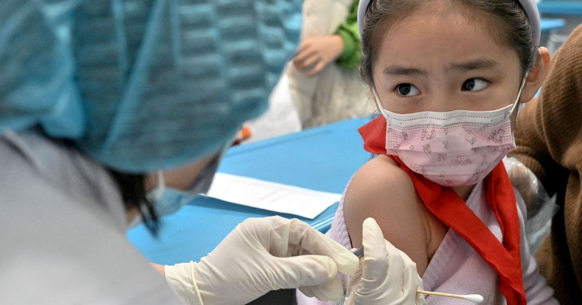 A child receives the COVID-19 vaccine at a school in Handan, in China's northern Hebi province on Wednesday after the city began vaccinating children between the ages of 3 to 11.