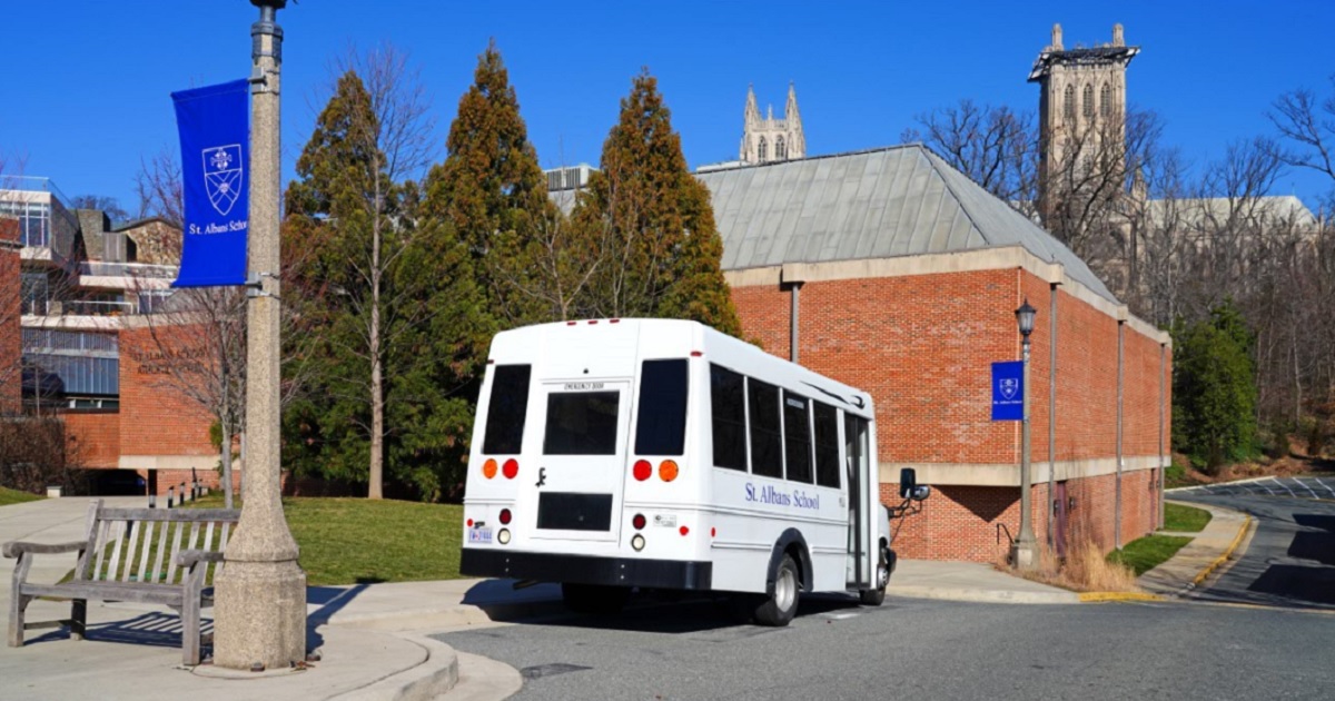 An exterior of St. Albans School with a van parked in front.