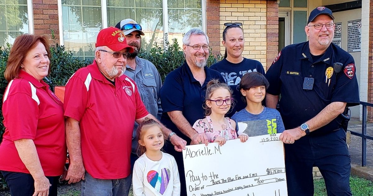 Abrielle presents a giant check to first responders