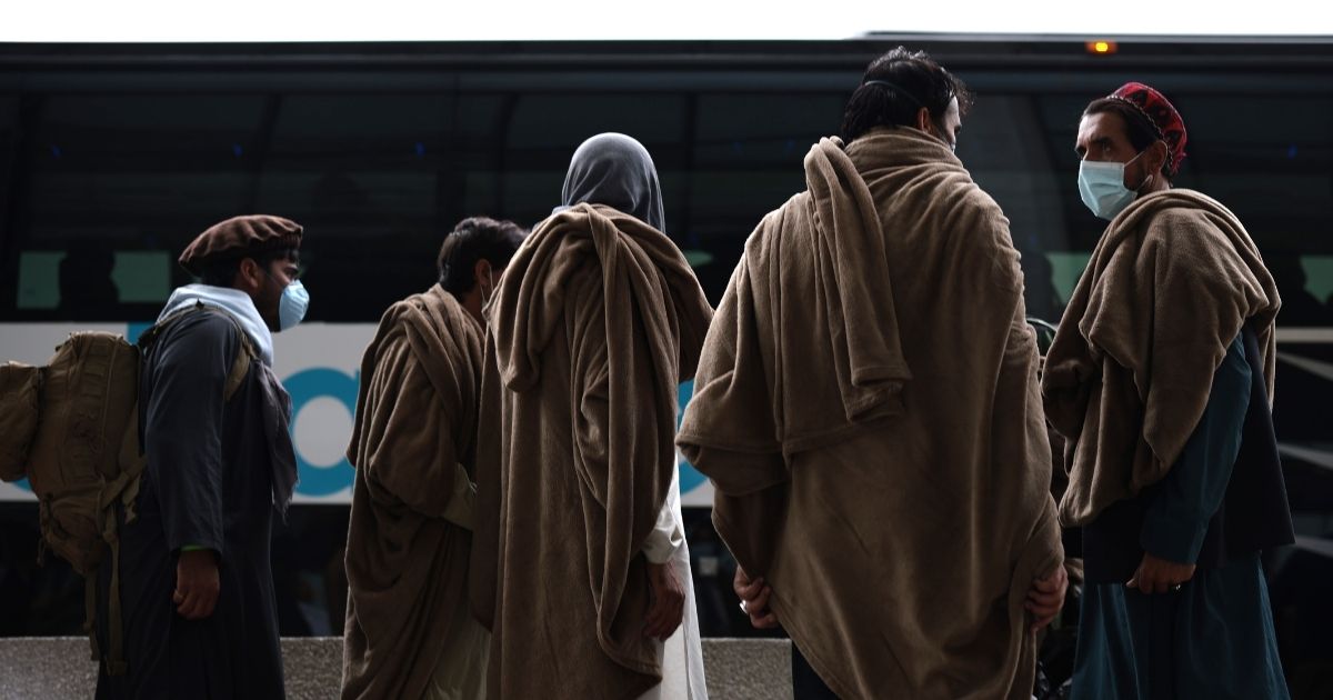 Afghan refugees board a bus at Dulles International Airport in Virginia that will take them to a refugee processing center on Aug. 31 after they were evacuated from Kabul following the Taliban takeover of Afghanistan.