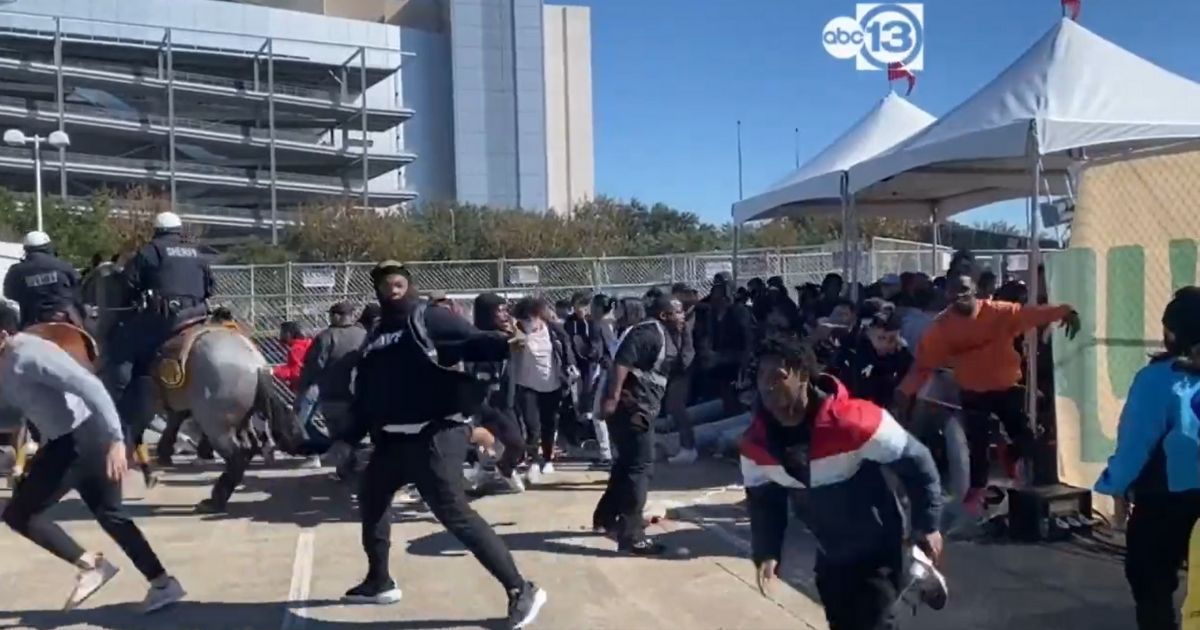 Crowds stampede through the security gate to get into the Astroworld Festival at NRG Park in Houston.