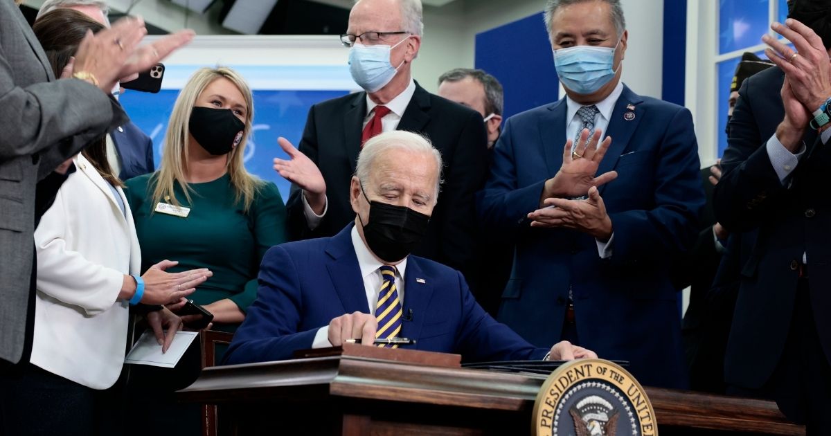President Joe Biden signs the "Colonel John M. McHugh Tuition Fairness for Survivors Act of 2021" into law at the Eisenhower Executive Office Building in Washington on Tuesday.