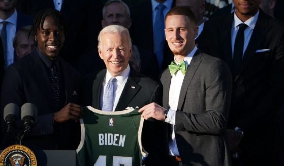 President Joe Biden poses with a jersey during an event honoring the 2021 NBA Championship Milwaukee Bucks on the South Lawn of the White House in Washington, D.C., on Monday.