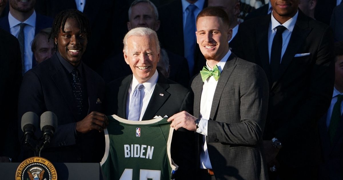 President Joe Biden poses with a jersey during an event honoring the 2021 NBA Championship Milwaukee Bucks on the South Lawn of the White House in Washington, D.C., on Monday.