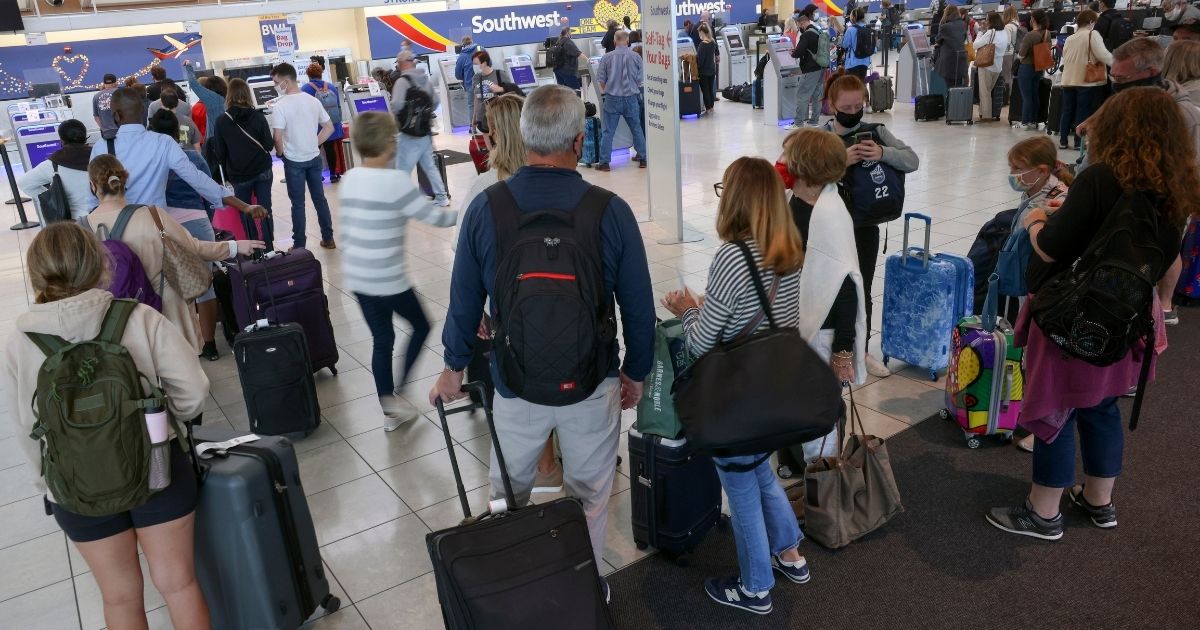 Travelers wait to check in at the Southwest Airlines ticketing counter at Baltimore Washington International Thurgood Marshall Airport on Oct. 11, 2021 in Baltimore.