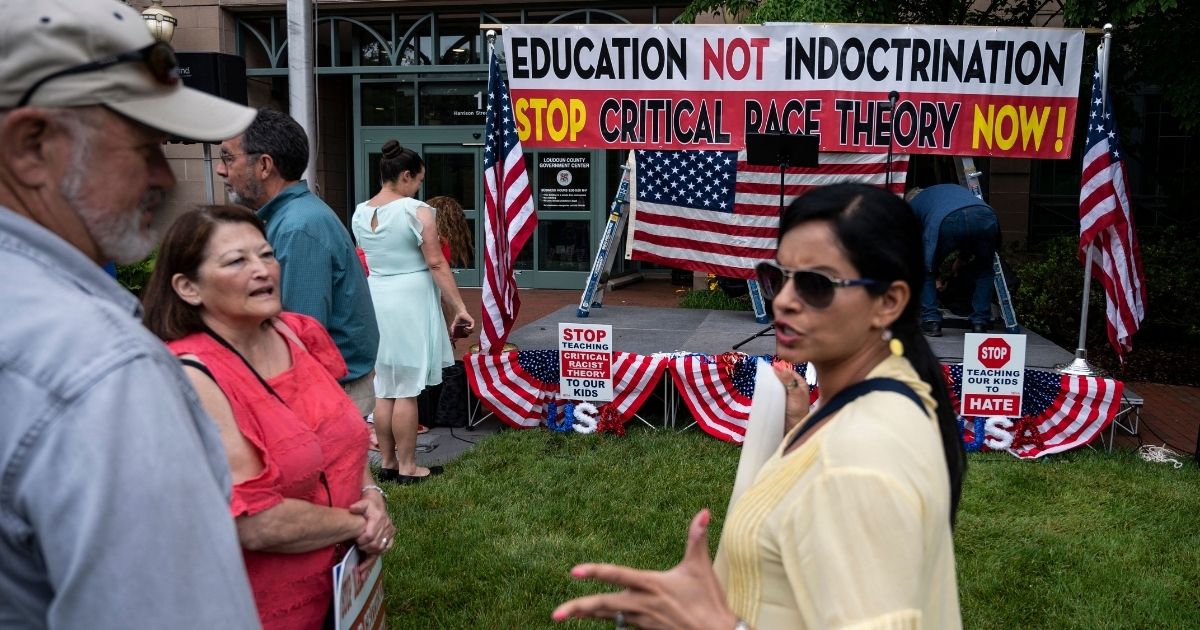 People talk before the start of a rally against critical race theory being taught in schools at the Loudoun County Government Center in Leesburg, Virginia, on June 12.