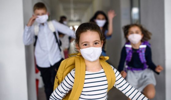 Children wearing masks are pictured in the stock image above.