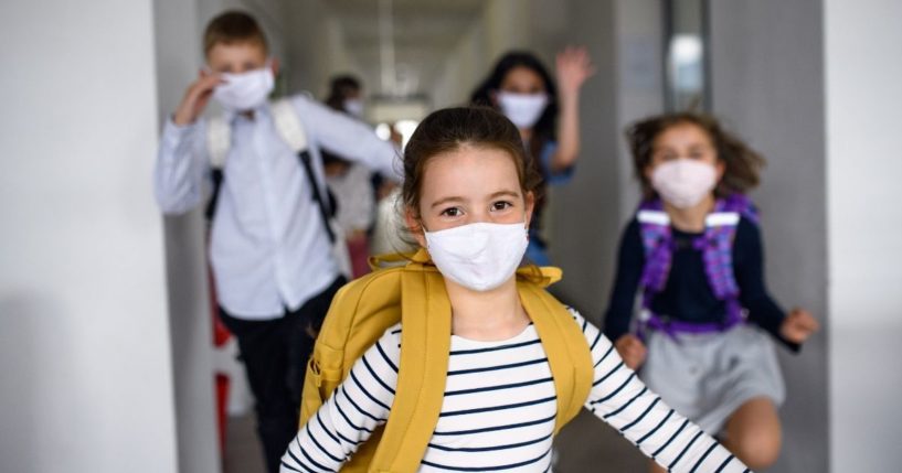 Children wearing masks are pictured in the stock image above.