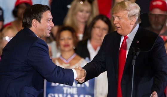 Then-President Donald Trump welcomes Ron DeSantis to the stage during a campaign rally for the then-Florida gubernatorial candidate at the Pensacola International Airport on Nov. 3, 2018.
