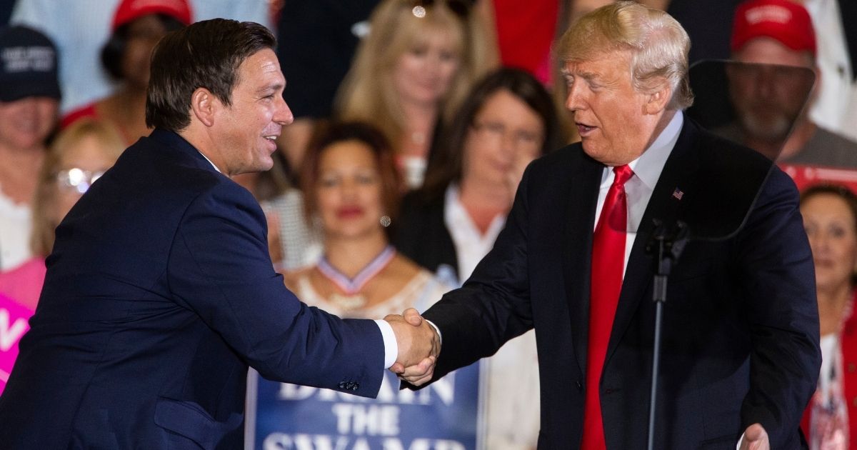 Then-President Donald Trump welcomes Ron DeSantis to the stage during a campaign rally for the then-Florida gubernatorial candidate at the Pensacola International Airport on Nov. 3, 2018.