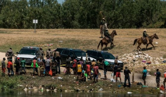 Border patrol officers detain a group of migrants after they crossed the Rio Grande near Del Rio, Texas, on Sept. 19.