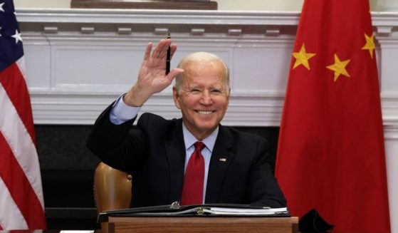 U.S. President Joe Biden waves as he participates in a virtual meeting with Chinese President Xi Jinping at the Roosevelt Room of the White House on Monday in Washington, D.C.