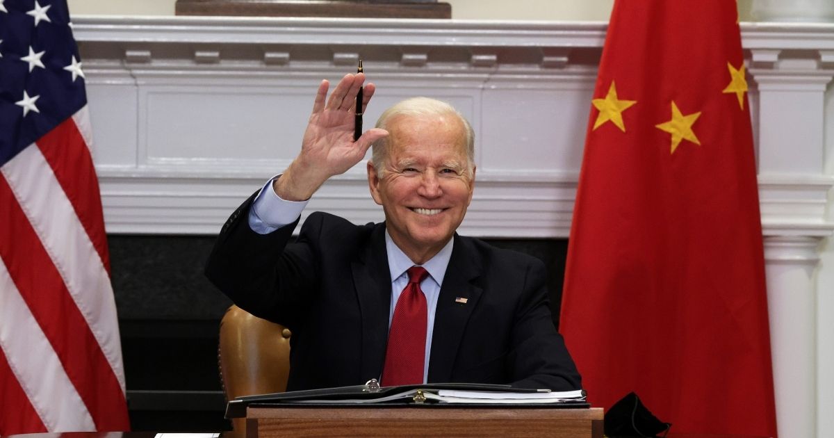 U.S. President Joe Biden waves as he participates in a virtual meeting with Chinese President Xi Jinping at the Roosevelt Room of the White House on Monday in Washington, D.C.