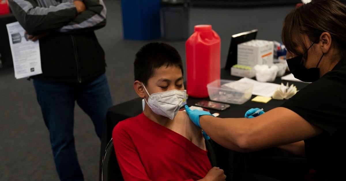 Johnny Thai, 11, receives the Pfizer COVID-19 vaccine at a pediatric vaccine clinic for children ages 5 to 11 set up at Willard Intermediate School in Santa Ana, California., November 9,2021. Study results reveal little difference in COVID infection rates between vaccinated and unvaccinated children.