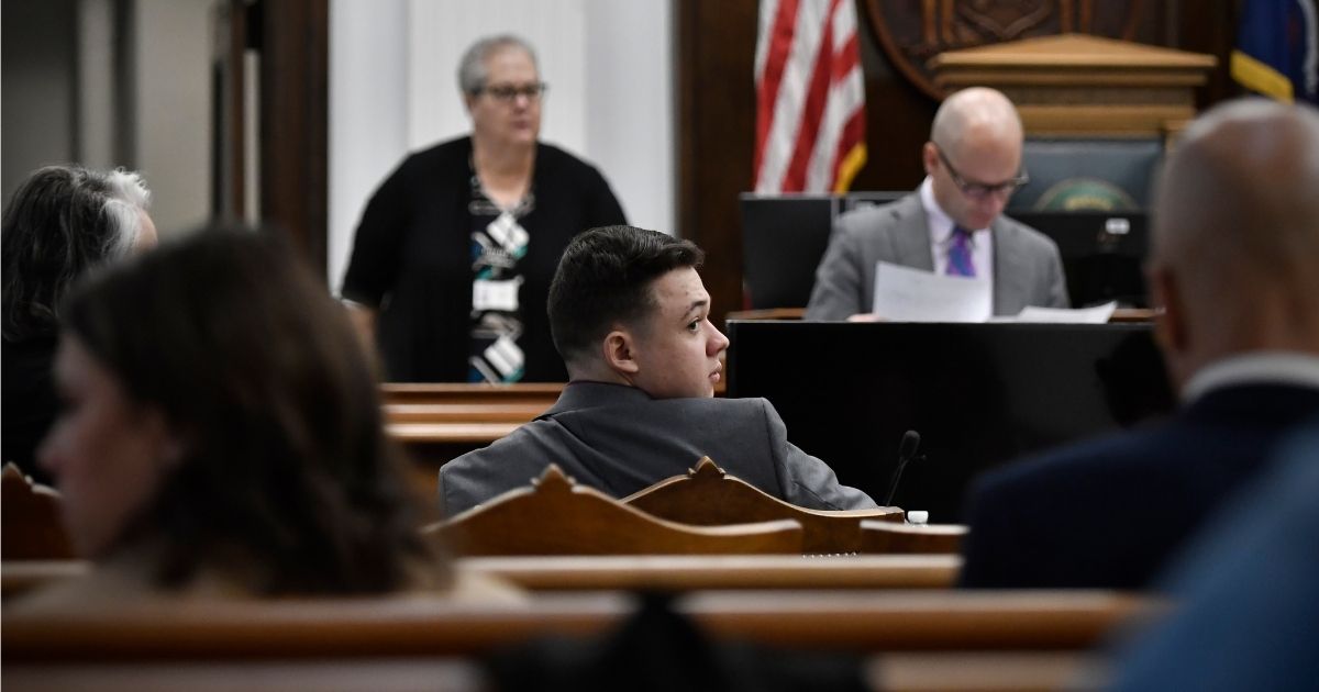 Kyle Rittenhouse, center, waits for the day's proceedings to begin at the Kenosha County Courthouse on Tuesday in Kenosha, Wisconsin.
