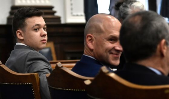 Kyle Rittenhouse looks back as he sits with his attorneys before the day starts at the Kenosha County Courthouse on Friday in Kenosha, Wisconsin.