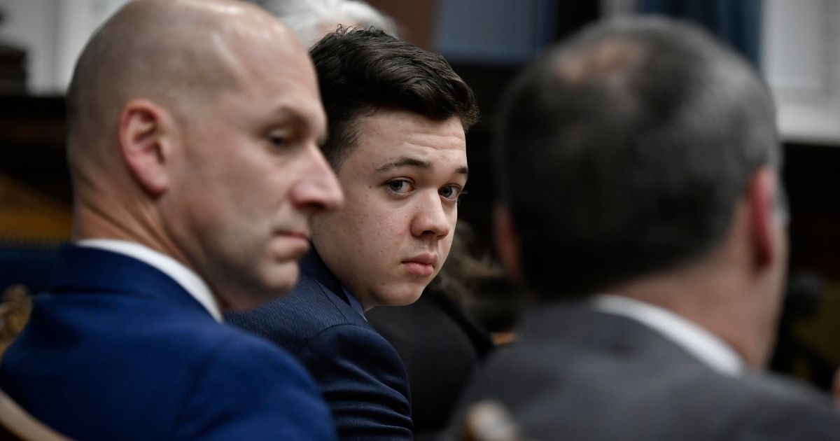 Kyle Rittenhouse, center, looks over to his attorneys as the jury is dismissed for the day during his trial at the Kenosha County Courthouse on Thursday in Kenosha, Wisconsin.