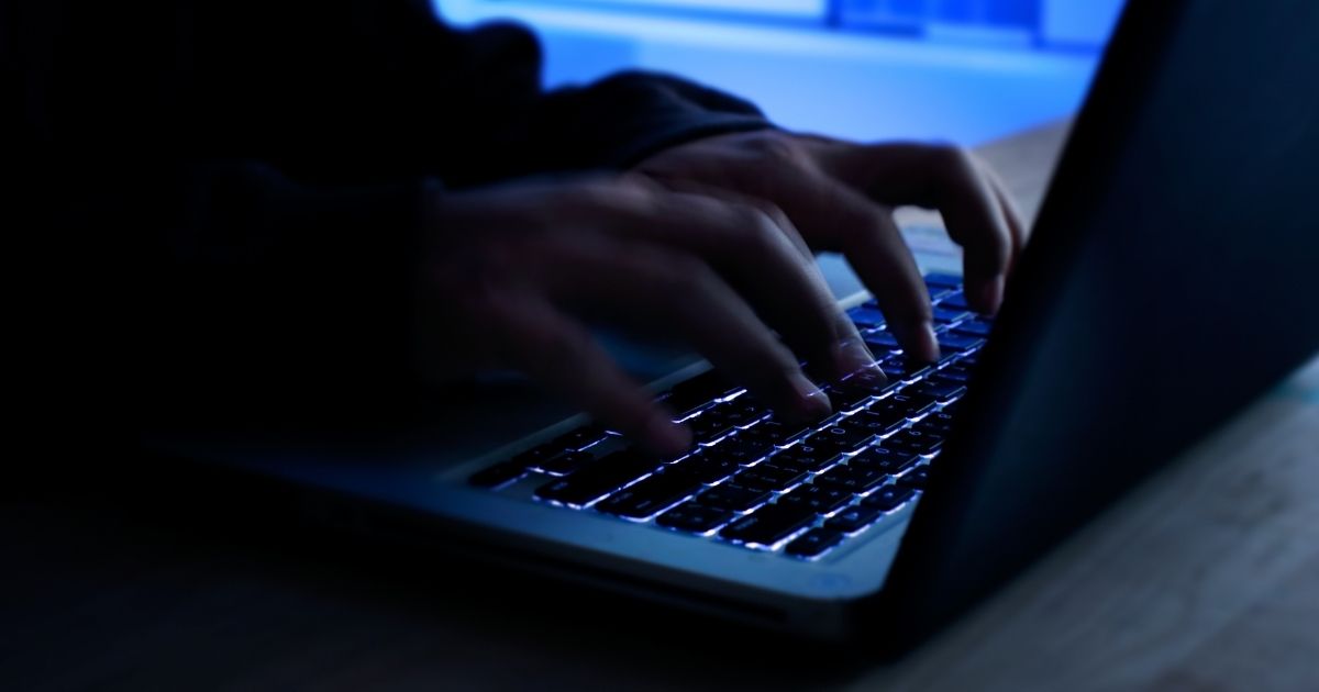 This stock image portrays a hacker typing information into a laptop. Two Iranian suspects are accused of downloading confidential data from 100,000 voters during the 2020 election period.