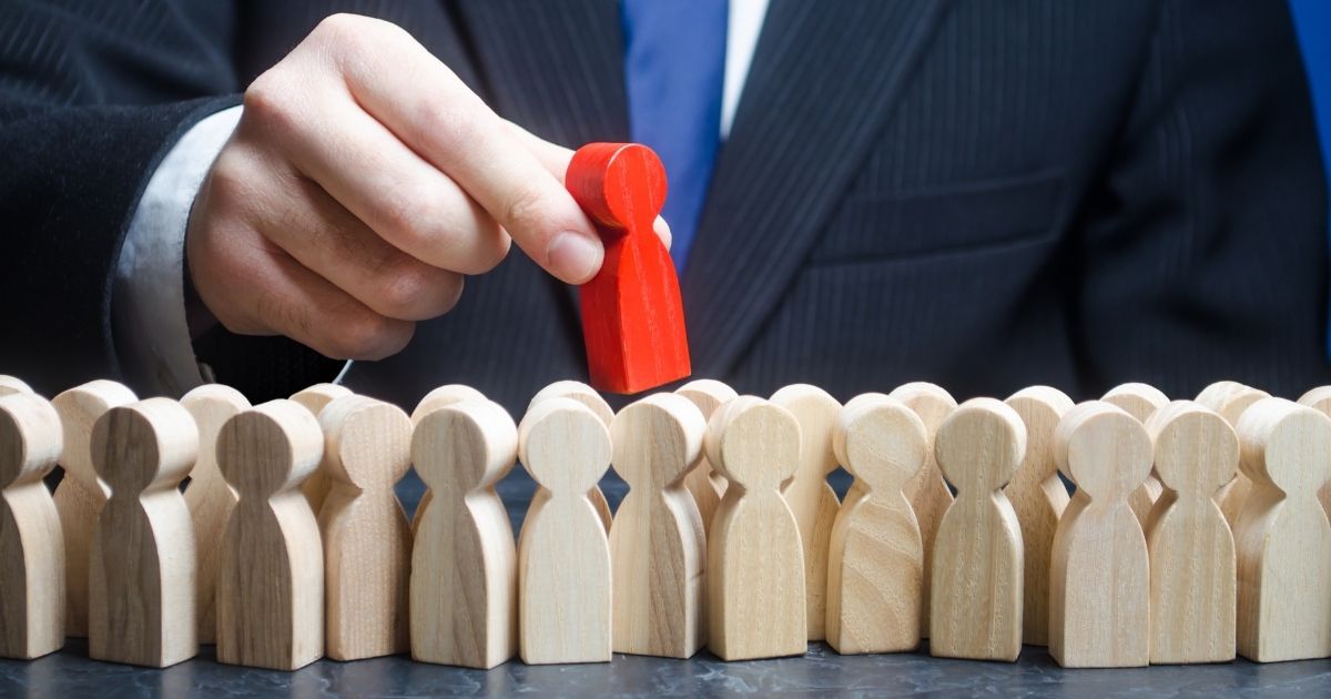 A businessman is seen with people-shaped blocks in the stock image above.