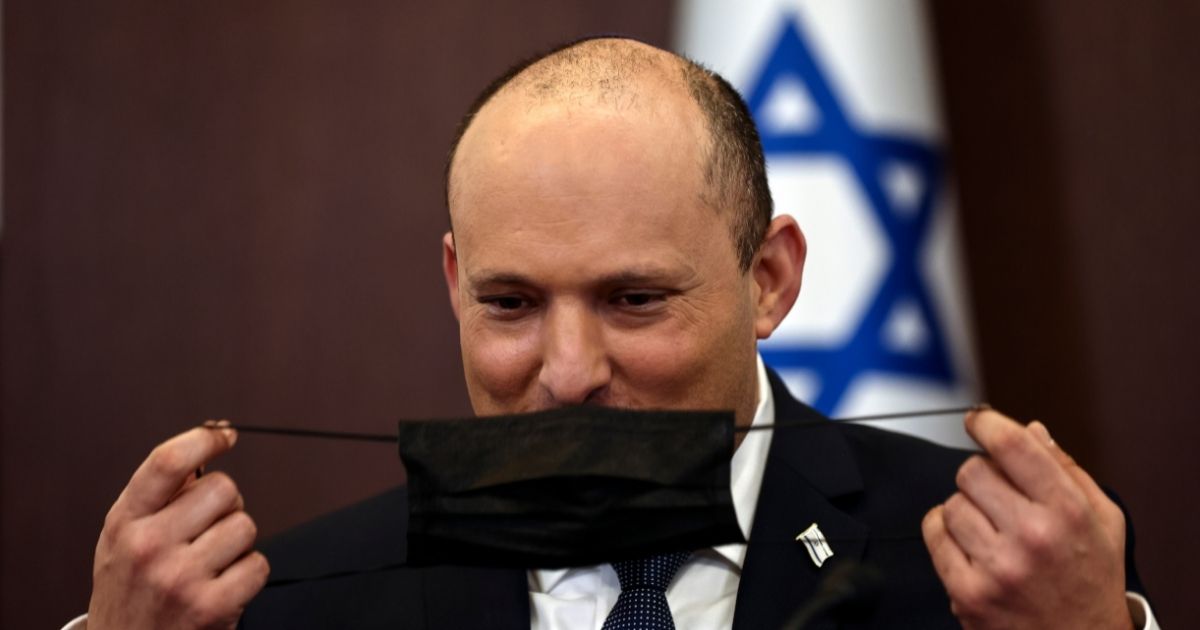 Israeli Prime Minister Naftali Bennett puts on his mask in a cabinet meeting in his office in Jerusalem on Sunday.