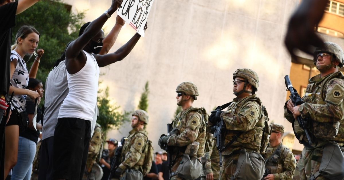 Oklahoma National Guard members form a line in front of Black Lives Matter protesters in Tulsa, Oklahoma, in this file photo from June 2020. The newly appointed commander of the Oklahoma National Guard has announced its members are no longer subject to President Joe Biden's COVID-19 vaccination mandate.