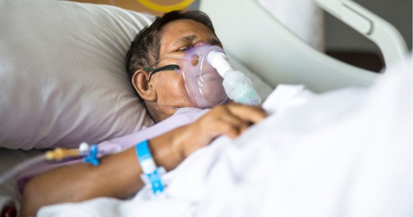 This stock image shows an older patient lying in a hospital bed with a ventilator machine. A new proposal may give insurance providers the ability to deny coverage if a patient with COVID-19 has not been vaccinated.
