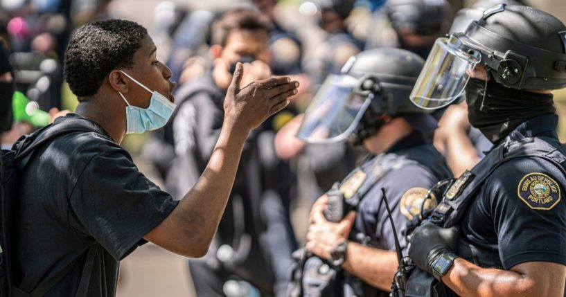 A demonstrator shouts at a Portland, Oregon, police officer during a protest following a shooting in Lents Park on April 16.