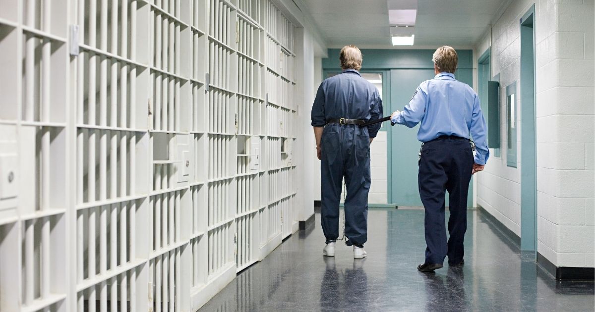 This stock image shows a prison guard leading an inmate down a hallway. In Colorado, officials moved to drop the term "sex offender" as it is too debilitating to sexual abusers.