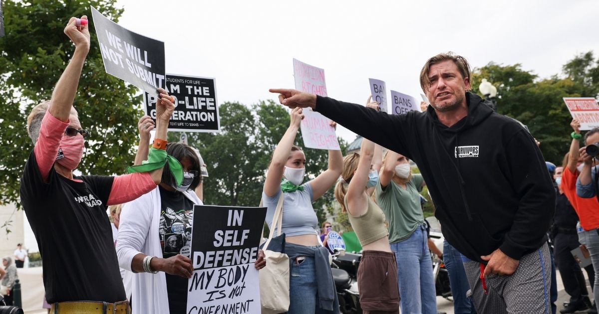 Pro-abortion and pro-life activists protest alongside each other during a demonstration outside of the Supreme Court on Oct. 4 in Washington, D.C.