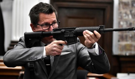 Assistant District Attorney Thomas Binger holds Kyle Rittenhouse's gun as he gives the state's closing argument in Kyle Rittenhouse's trial at the Kenosha County Courthouse on Monday in Kenosha, Wisconsin.