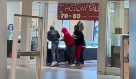 Shoplifters break glass in jewelry cases and grab items at Sam's Jewelers at Southland Mall in Hayward, California, on Sunday.