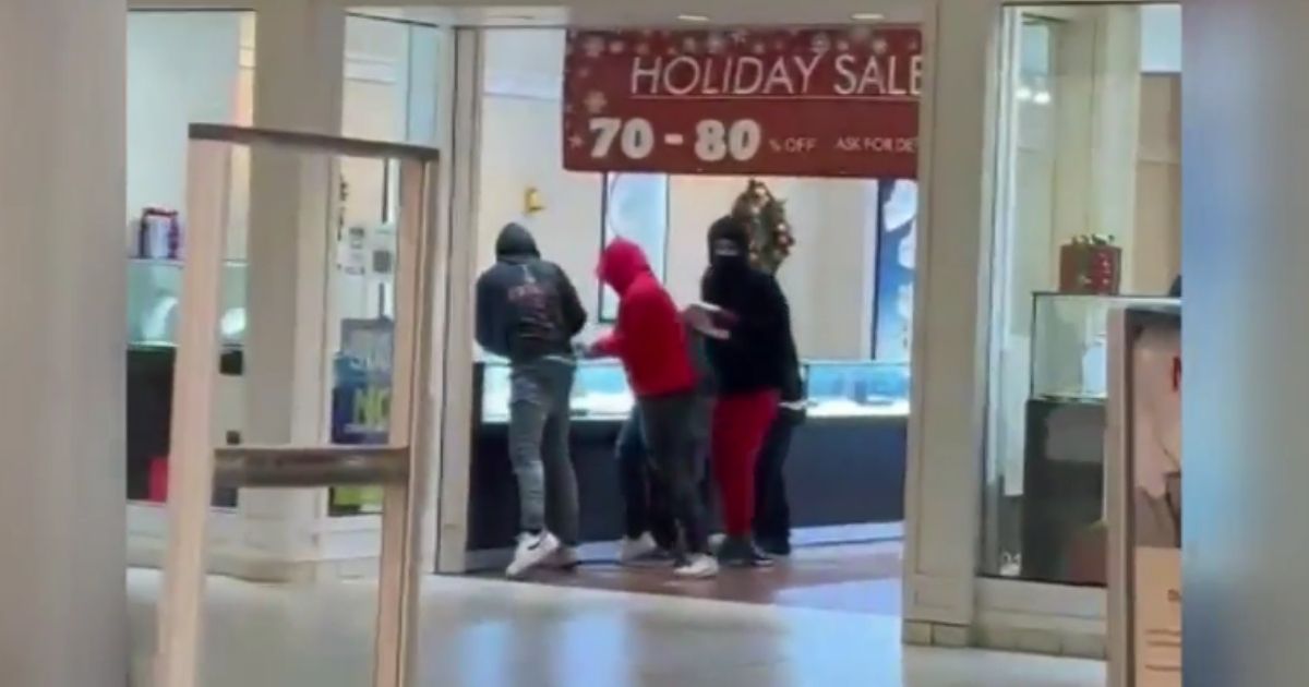 Shoplifters break glass in jewelry cases and grab items at Sam's Jewelers at Southland Mall in Hayward, California, on Sunday.